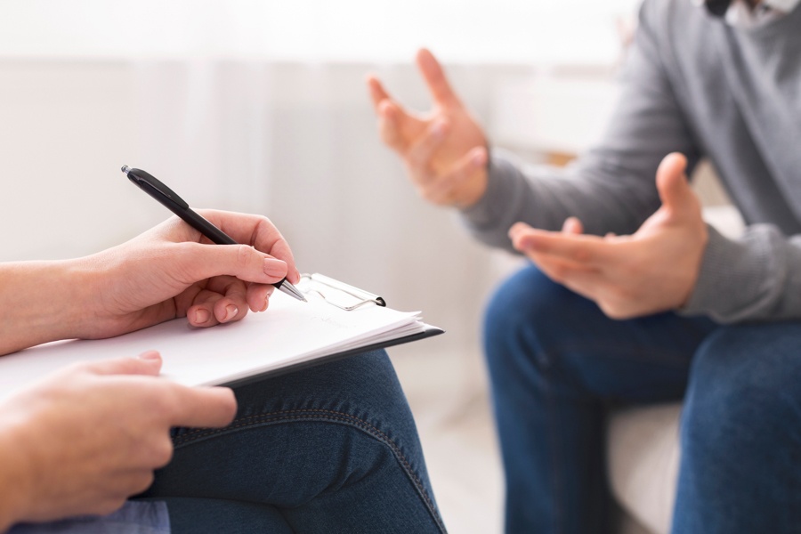 Therapist explaining behavioral signs of addiction during a counseling session
